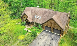 A wooden cabin with a porch, garage, and satellite dish. - Jake’s Lodge w/ Hot Tub,  Sleeps 14 , located in Hocking Hills (Logan)