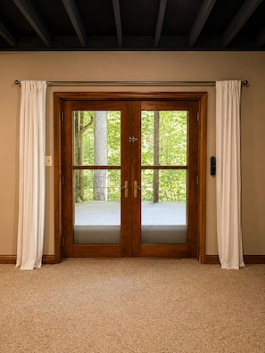 A room with a wooden door, beige carpet, and curtains. - Jake’s Lodge w/ Hot Tub,  Sleeps 14 , located in Hocking Hills (Logan)