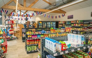 Ein Supermarkt mit verschiedenen Gängen, gefüllt mit Waren wie Milchprodukten, Snacks und Getränken.