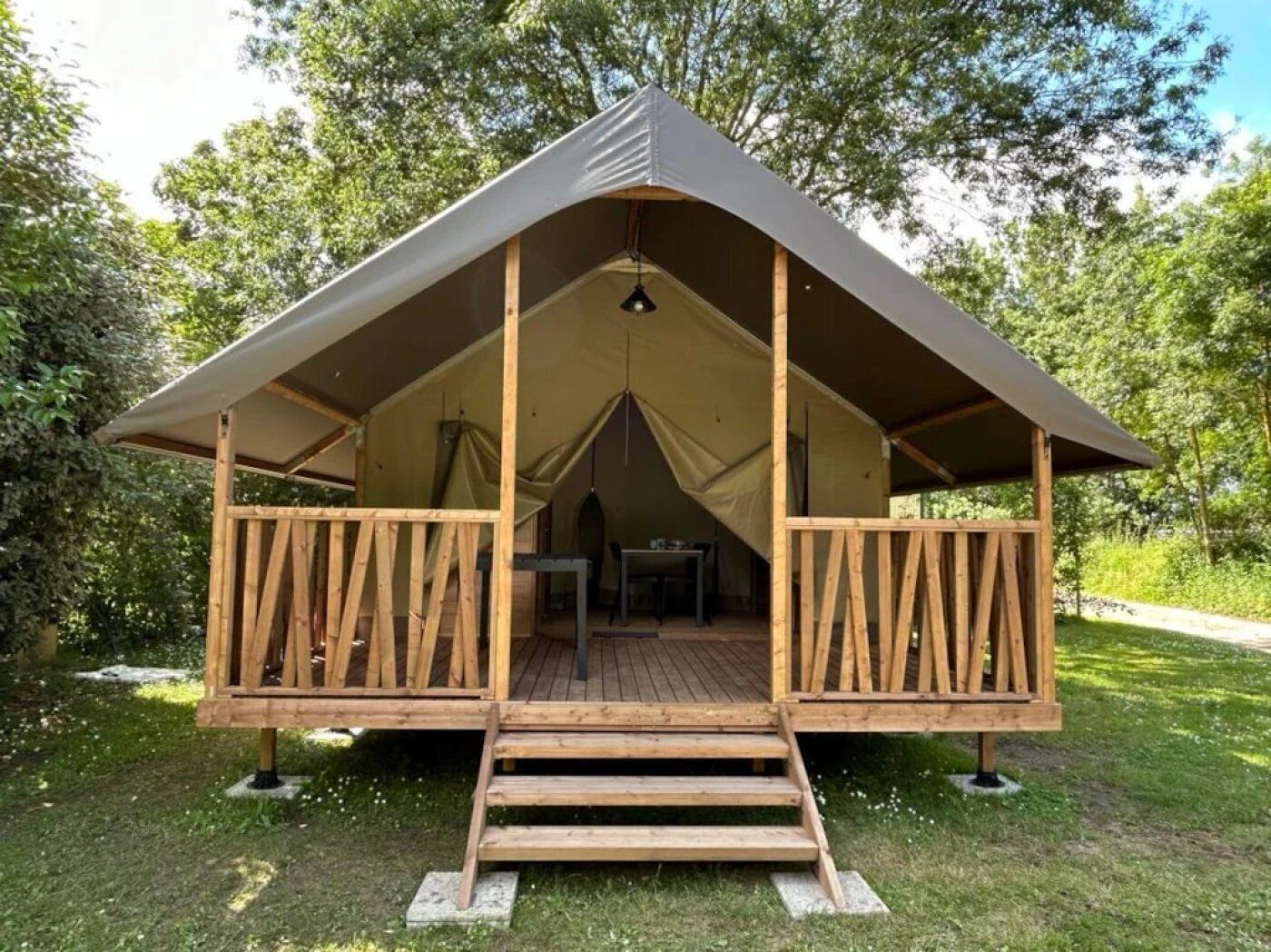 A tent with a wooden deck and a table inside.