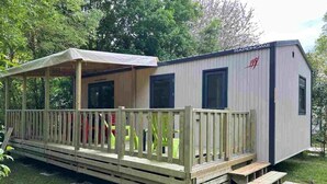 A mobile home with a covered porch, a small deck, and a ramp leading to the entrance. - Camping 4 étoiles - Piscine  - ccbgagb (Concourson-sur-Layon)