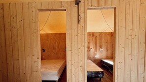 Ein Zimmer mit Holzwänden, zwei Betten und einem kleinen Tisch.