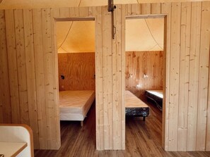 Ein Zimmer mit Holzwänden, zwei Betten und einem kleinen Tisch.
