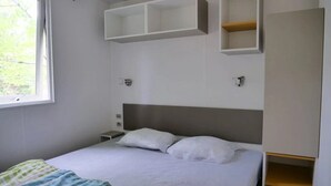 Une chambre à coucher avec un lit, une fenêtre et des étagères intégrées.