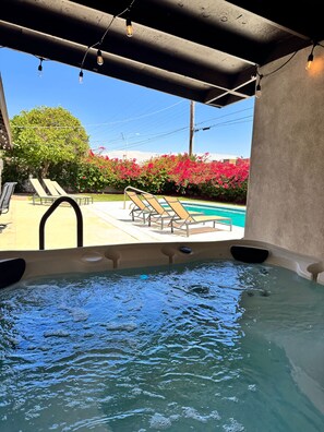 A hot tub with a pool view, lounge chairs, and a covered area with string lights. - Pet-Friendly Scottsdale Retreat w/ Pool & Hot Tub (Scottsdale)
