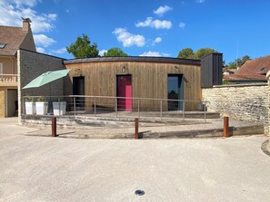 A building with a stone facade, a wooden structure, and a red door.