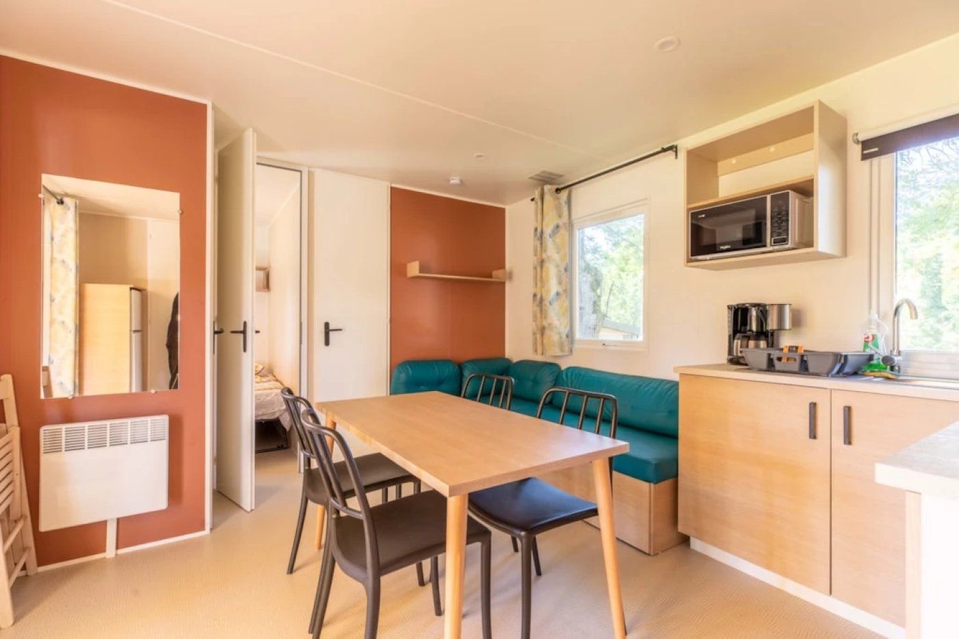 Una cocina compacta con mesa y sillas, un rincón americano y un sofá.