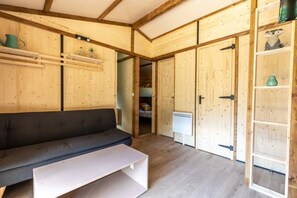 Et interiør i træ med en sofa, et hvidt bord og et garderobeskab.