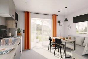 Eine moderne Küche mit einem Gasherd, einem Essbereich mit Tisch und Stühlen sowie einem Sofa.