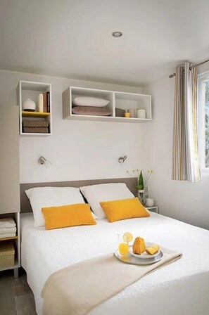 Ein ordentlich eingerichtetes Schlafzimmer mit einem Bett, Nachttischen und eingebauten Regalen.