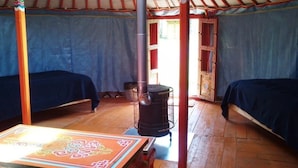 A room with two beds, a heater, and a table with a decorative cloth. - Camping 3 étoiles - ccbgcgd (Prads-Haute-Bléone)