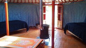 Ein Zimmer mit zwei Betten, einer Heizung und einem Tisch mit dekorativer Tischdecke.