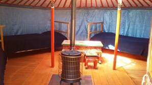 A room with a central heater, two beds, a small table, and a chair. - Camping 3 étoiles - ccbgcgd (Prads-Haute-Bléone)