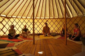 A group of people sitting on mats inside a tent with a wooden floor. - Chalet 3 étoiles - ccbgche (Prads-Haute-Bléone)