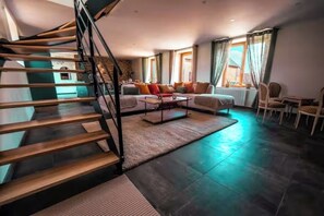 A modern living room with a staircase, a sofa set, and a dining area. - La Belle Aire, at Christophe's (Le Fœil)