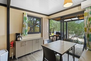 Une cuisine moderne équipée d’une machine à café, d’un extincteur et offrant une vue sur l’extérieur.