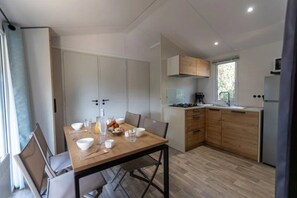 Eine kleine Küche mit Esstisch, gedeckt für das Frühstück, einem Herd und einem Kühlschrank.