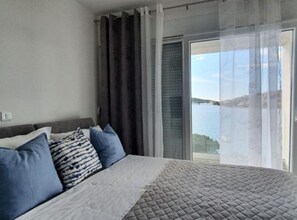 Ein Schlafzimmer mit Bett, Meerblick und Balkon.