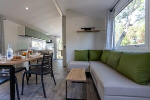 Ein modernes Wohnzimmer mit einer Couch und einem Essbereich mit Tisch und Stühlen.