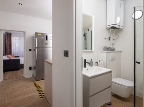 A modern hotel room with a kitchenette, a bathroom with a toilet and sink, and a bed with a view. - One Bedroom Apartment with Terrace and SeaView(A3) (Omis)