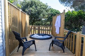 A wooden deck with a hot tub, two chairs, and a towel rack. - Camping 3 étoiles - Piscine  - ccbgec0 (Pianottoli-Caldarello)