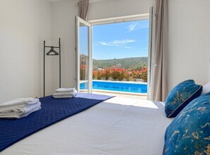 Une chambre d’hôtel avec un lit, une vue sur la piscine et un balcon.