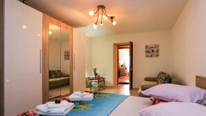 Habitación de hotel con cama, una silla, una mesita, armario y espejo.