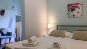 Une chambre d’hôtel avec un lit, une chaise, une lampe et un tableau au mur.