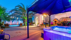 A poolside area with a hot tub, lounge chairs, and a covered seating area. - One Bedroom Apartment with Balcony (Sukosan)