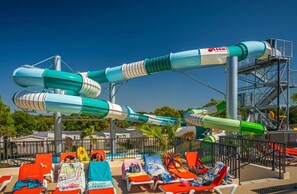 Een waterpark met meerdere glijbanen en ligbedden.