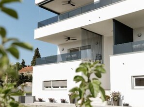 Ein modernes, zweistöckiges Gebäude mit Flachdach, großen Fenstern und einem Balkon.