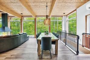 A dining area with a long table, chairs, and a bench along the wall. - Vrbo Property (La Conception)