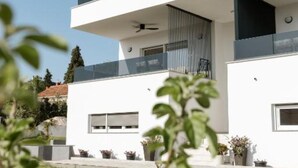 Ein modernes, zweistöckiges Gebäude mit Flachdach, großen Fenstern und einem Balkon.