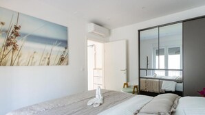 Ein Schlafzimmer mit zwei Betten, einem großen Spiegel und einem Schilfbild.