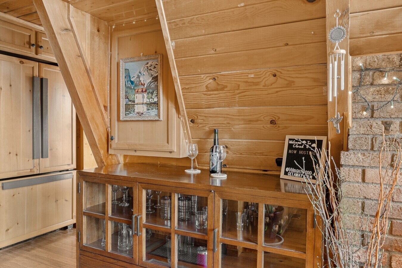 A wooden interior with a bar area, wooden cabinets, and a chalkboard sign.