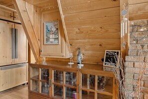 A wooden interior with a bar area, wooden cabinets, and a chalkboard sign.