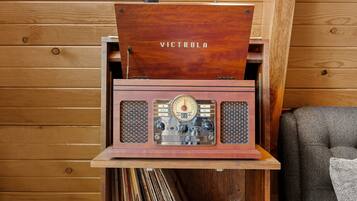 A wooden cabinet with a vintage radio, a lamp, and vinyl records.
