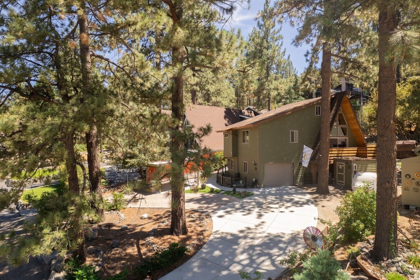 A two-story building with a sloped roof, surrounded by pine trees.