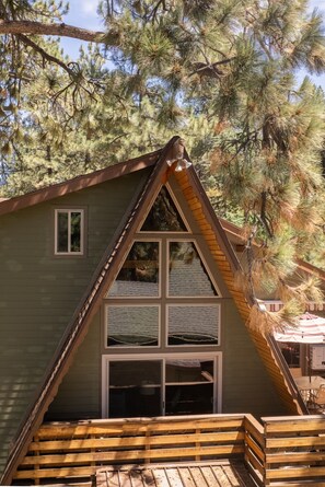 A cabin with a steeply pitched roof, large windows, and a wooden deck. - Cloud 9 Cozy A-Frame | Wrightwood Escape (Wrightwood)