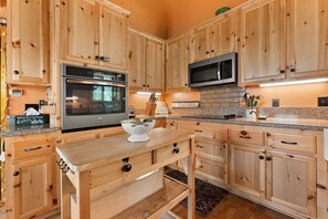 A kitchen with wooden cabinets, stainless steel appliances, and a granite countertop. - Cloud 9 Cozy A-Frame | Wrightwood Escape (Wrightwood)