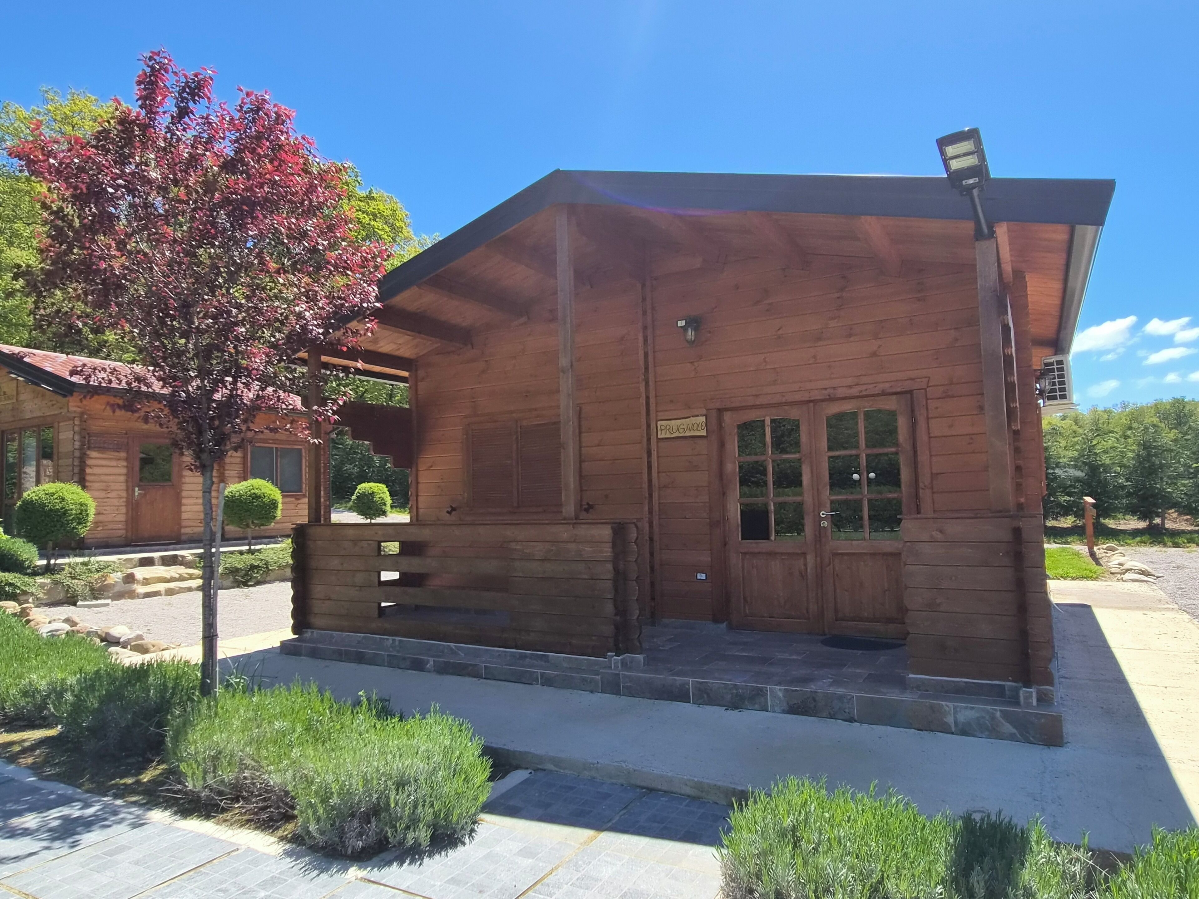 A wooden cabin with a porch, a small window, and a door.