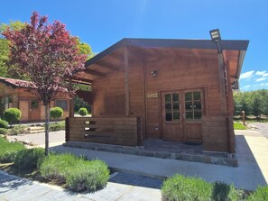 A wooden cabin with a porch, a small window, and a door.