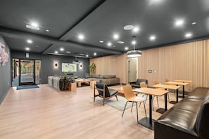 Ein modernes Interieur mit Holzboden, einer Couch, Tischen und einem Fernseher.