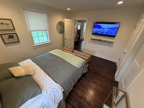 A bedroom with a bed, a television, a window, and a door leading to another room. - Retreat with spa and amazing outdoor space. 5 miles to downtown Chattanooga (Rossville)