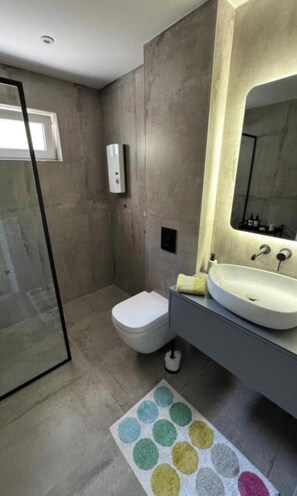 Ein modernes Badezimmer mit Dusche, Toilette und Waschbecken.