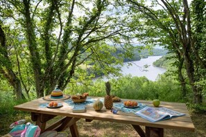 Ein Picknicktisch im Freien mit Blick auf einen See und Wald.