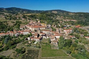 Une vue aérienne d’une ville avec une église imposante, des immeubles résidentiels et une végétation luxuriante environnante.