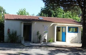 A small building with a red-tiled roof, a blue door, and a small window. - Camping 3 étoiles - Piscine  - ccbfgda (Les Achards)