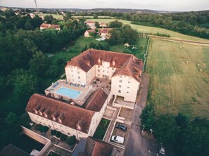 An aerial view of a large, multi-story building with a swimming pool, surrounded by greenery and a rural landscape. - Appartement 3 étoiles - Piscine  - ccbgfcf (La Roche-Posay)