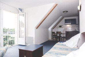 Ein gemütlicher Raum mit Balkon, einer Küchenzeile und einem Bett.